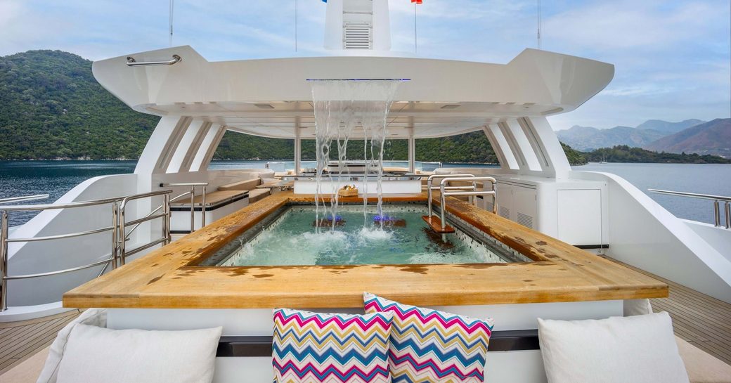 Overview of the deck Jacuzzi and waterfall feature on the sun deck of charter yacht FORTUNA 