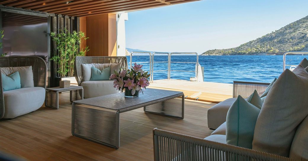 Beach club with interior seating and waterside terrace onboard charter yacht PROJECT X