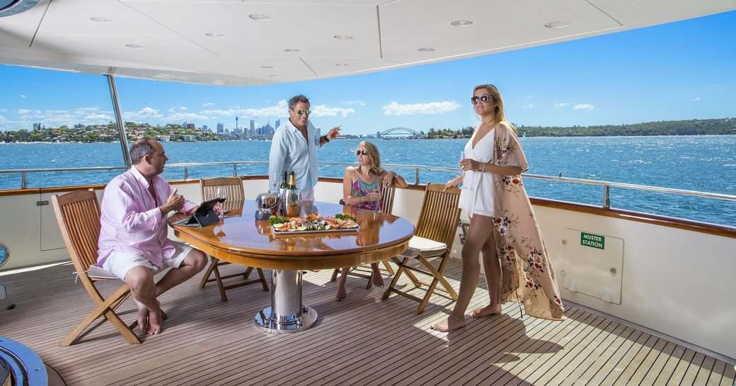 charter guests enjoy food and champagne on board motor yacht ‘Lady Pamela’ 