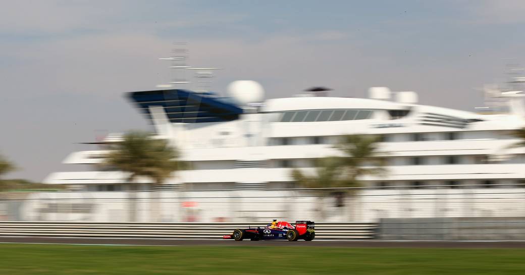 Car in focus as it goes past superyacht during the Abu Dhabi Grand Prix Formula 1 Raceweek