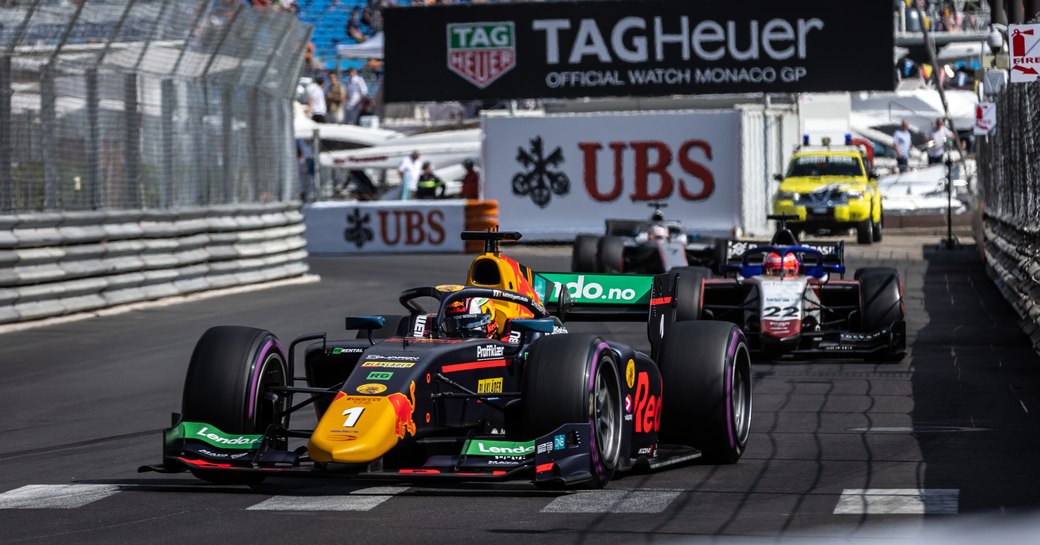 Ground level view of the Monaco Grand Prix underway, with racers on the track and spectators in the stands behind