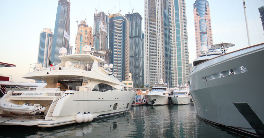 Luxury yachts in marina in Dubai with skyscrapers in background