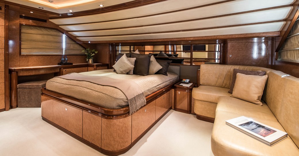 Elegant mastersuite on Superyacht Queen of Sheba with bed and leather sofa visible