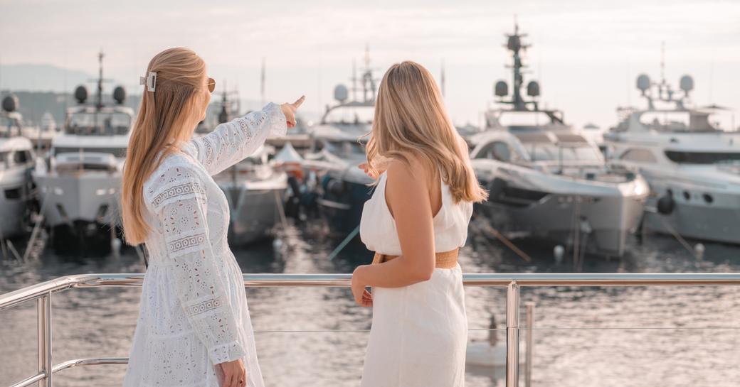 Two visitors at the MYS looking out over berthed superyachts