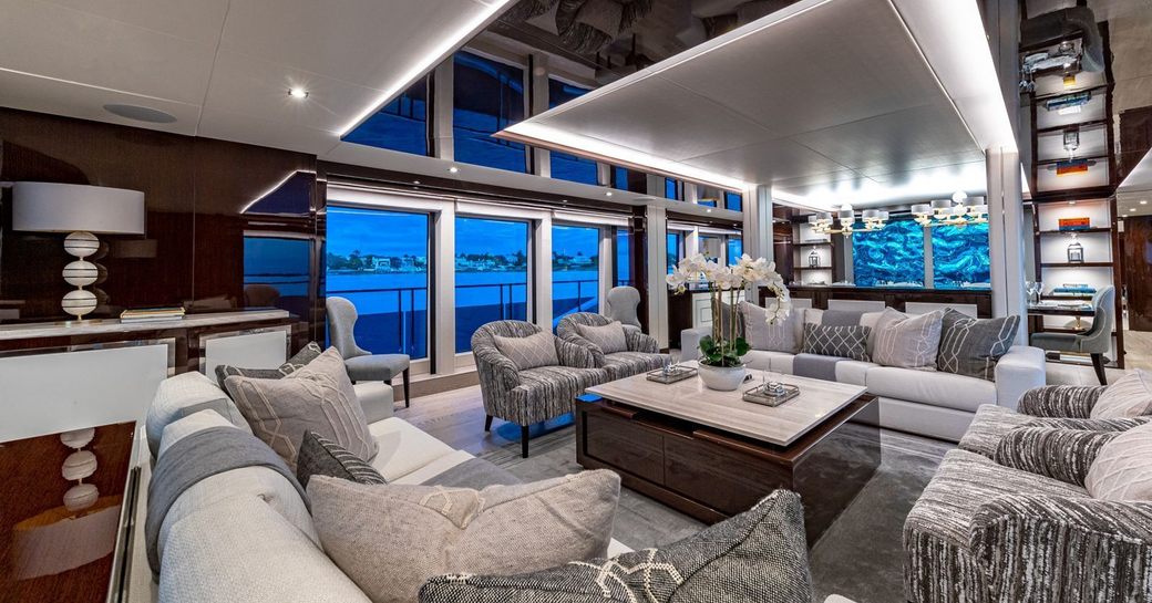 Main salon lounge with plush white and gray seating onboard charter yacht TC 