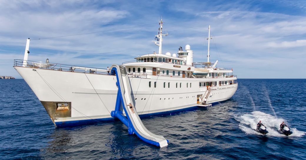 charter guest tries out the inflatable water slide on board motor yacht SHERAKHAN