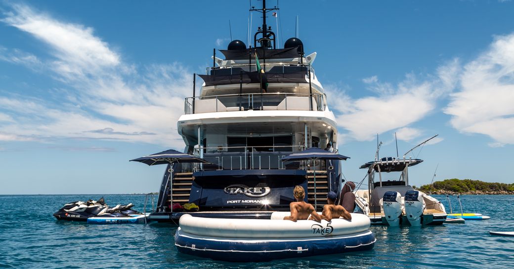 water toys laid out on the waters surrounding the swim platform of luxury yacht Take 5
