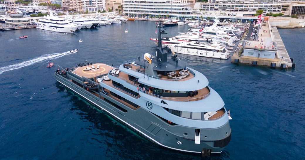 Explorer yacht RAGNAR arriving at Yacht Club de Monaco in  busy port with town in background