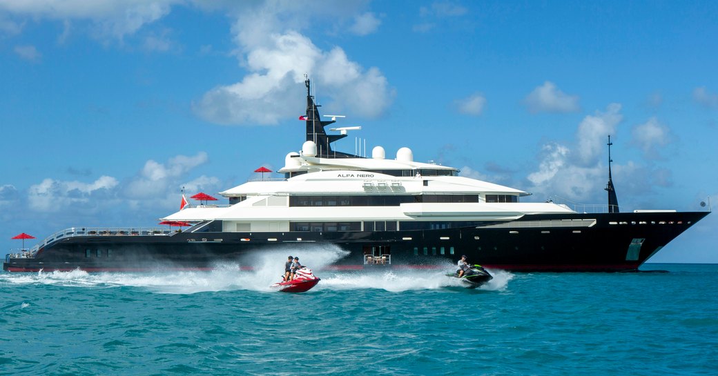 Charter yacht ALFA NERO at anchor with charter guests on Jet Skis