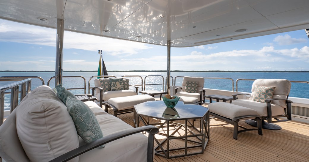 Covered area on deck of superyacht ZEAL with comfortable seats