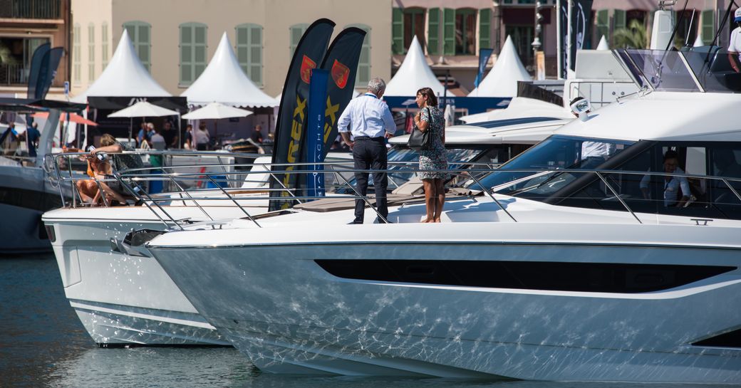 People standing on the bow of a superyacht at the Monaco Yacht Show