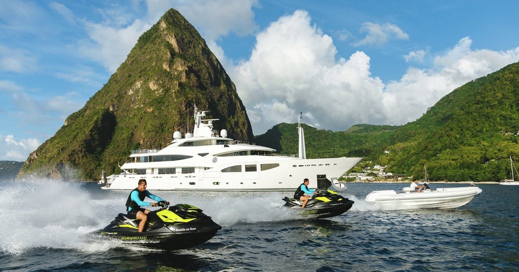 superyacht Ramble on Rose cruises alongside charter guests on jet skis 