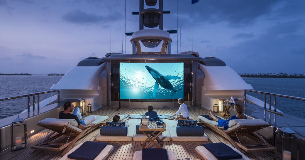 family enjoying the outdoor cinema at night onboard charter yacht calypso