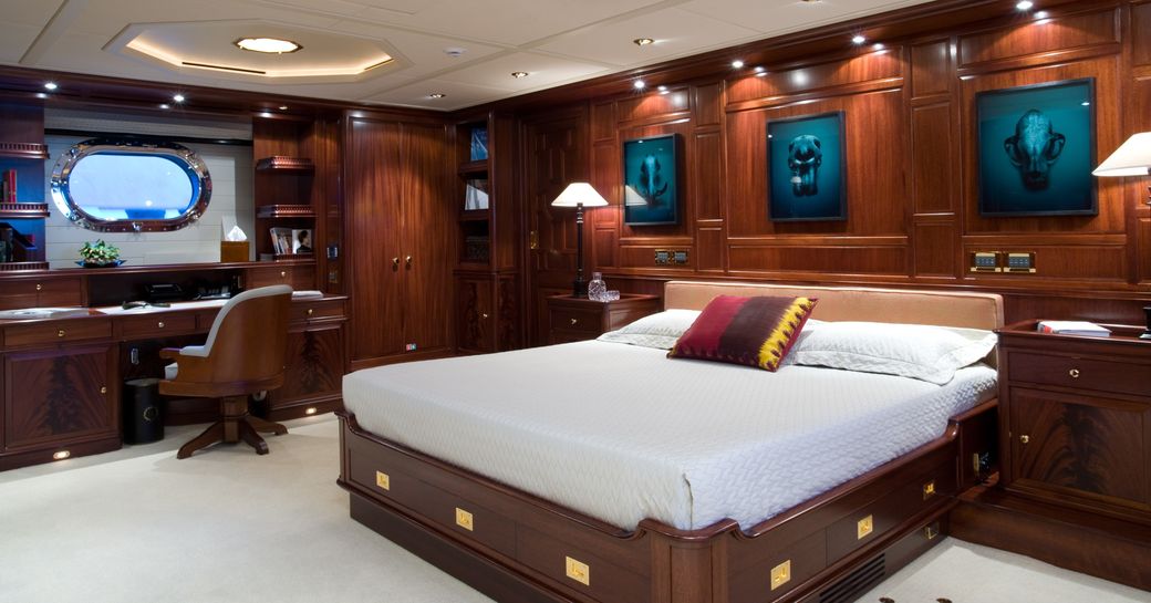 mahogany-clad master suite with large bed and classic styling on board charter yacht BLUSH 