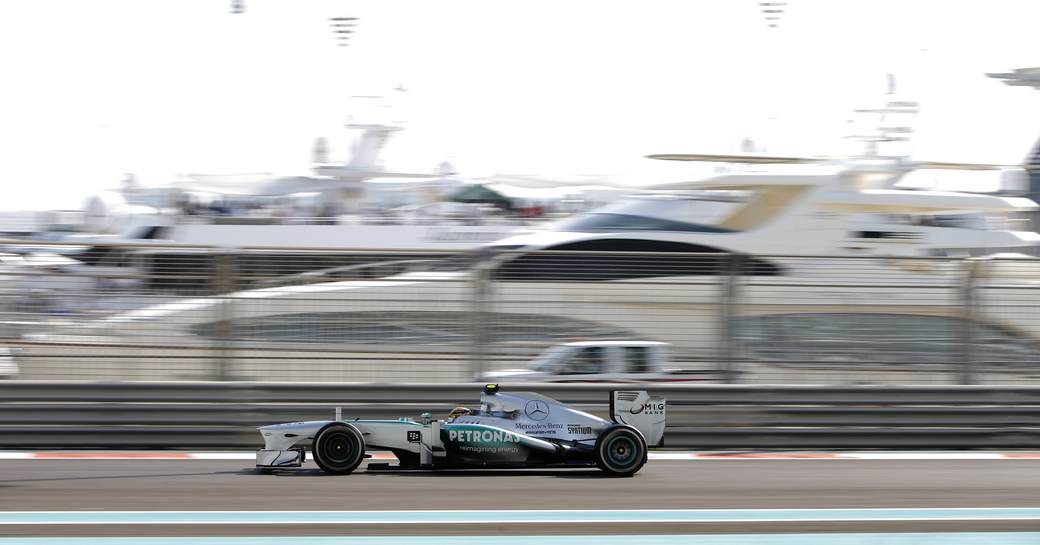 formula one car racing on the track past a superyacht at the Abu Dhabi Grand Prix