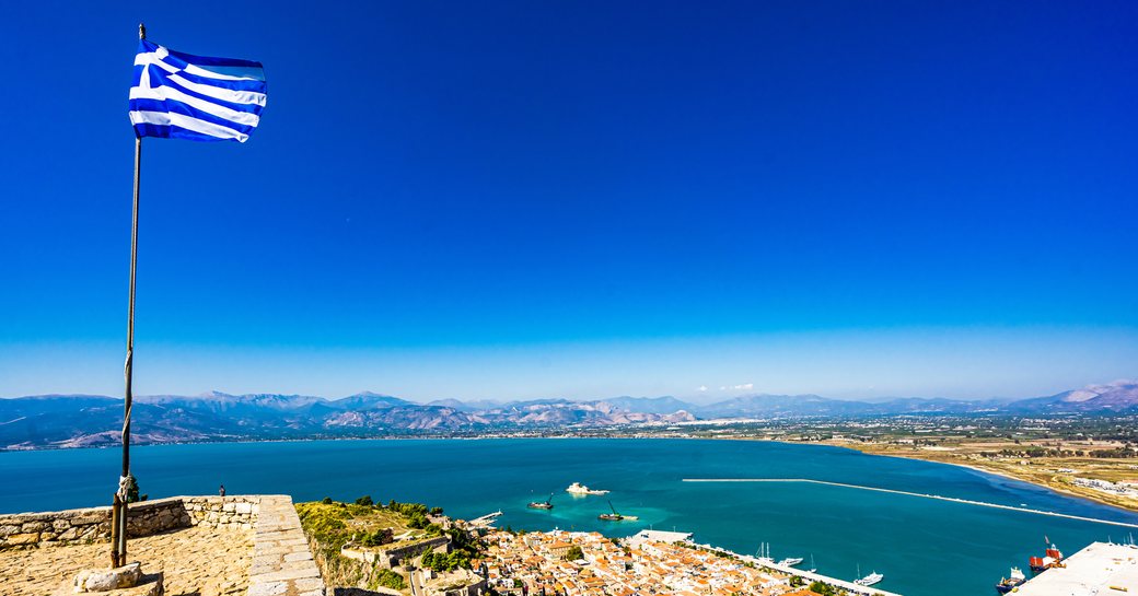 Greek flag flying on top of hill overlooking Aegean Sea
