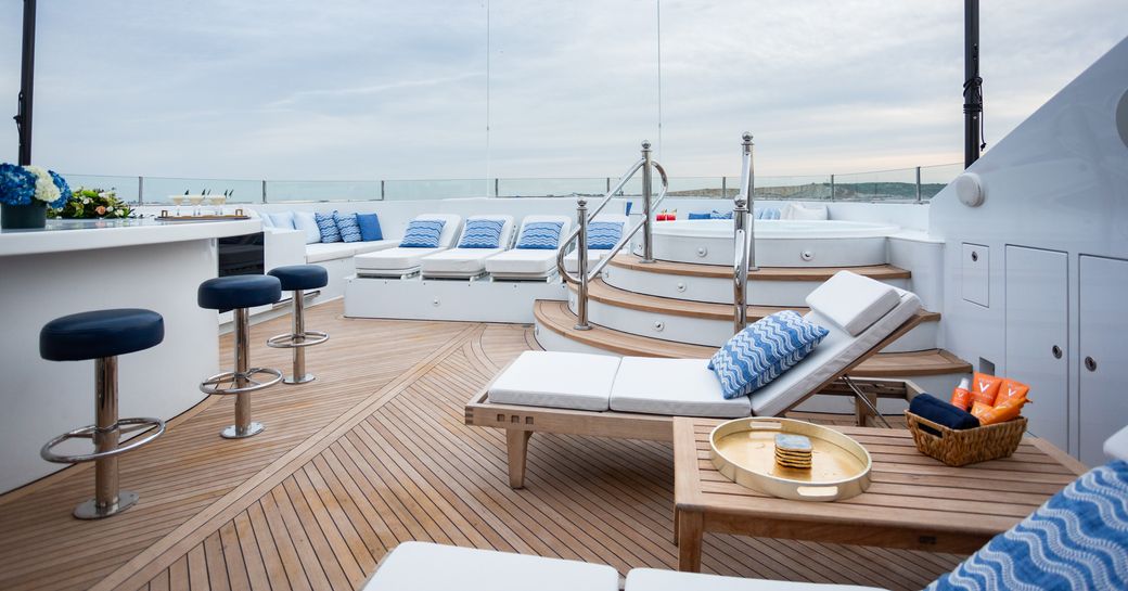 Exterior deck space onboard charter yacht PURPOSE, wet bar to port side and a deck Jacuzzi in the background
