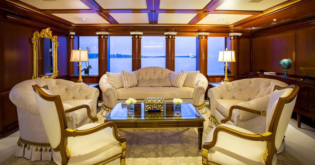 seating area with wing back sofa and matching armchairs in the main salon of charter yacht ‘My Seanna’ 