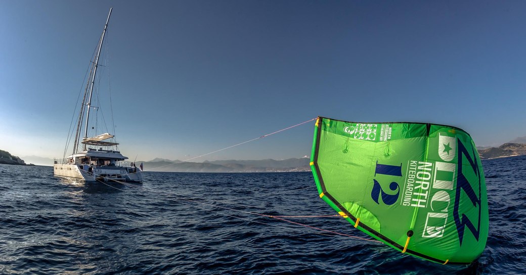 luxury yacht Ocean View tugs along a green kite while on a Tahiti yacht charter