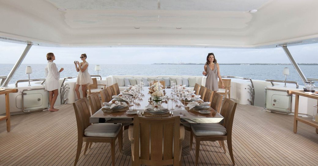 charter guests gather on the al fresco dining area of the sundeck on board luxury yacht Lady E