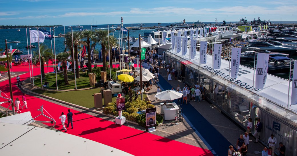 Overview of the Cannes Yachting Festival with a red carpet running along the front of the extensive Ferretti Group exhibit.