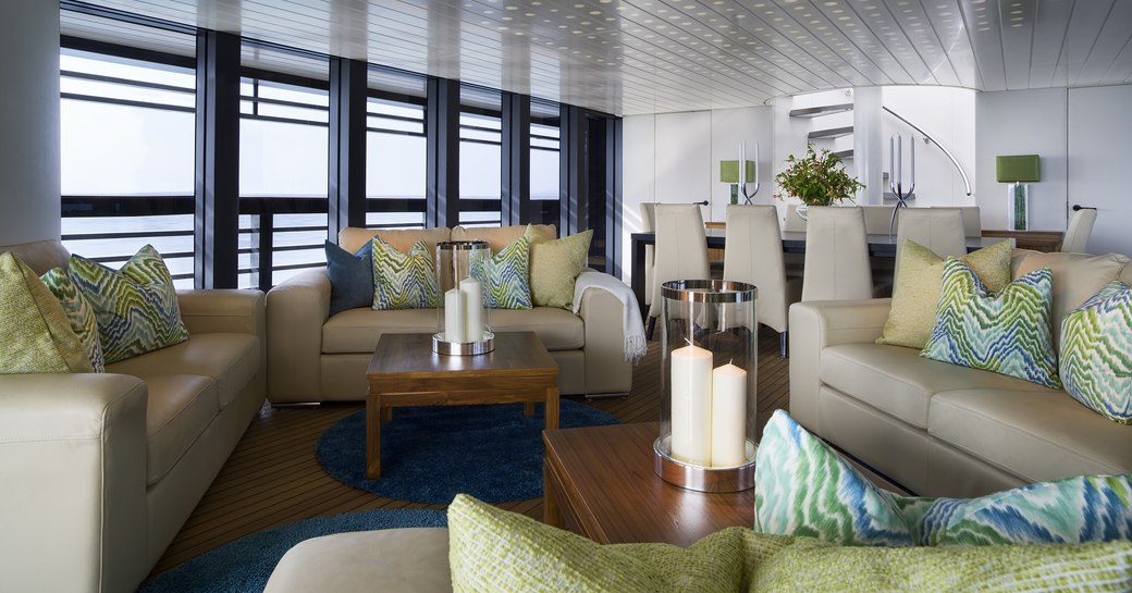 cream sofas in the full-length window-flanked main salon aboard superyacht Ocean Emerald 