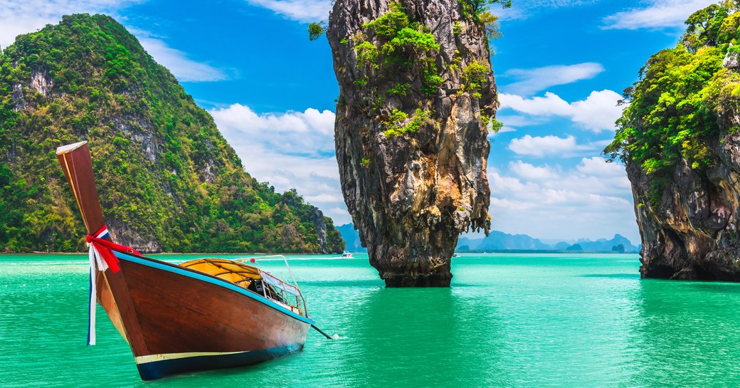 Thailand islands with towering karst and traditional long boat