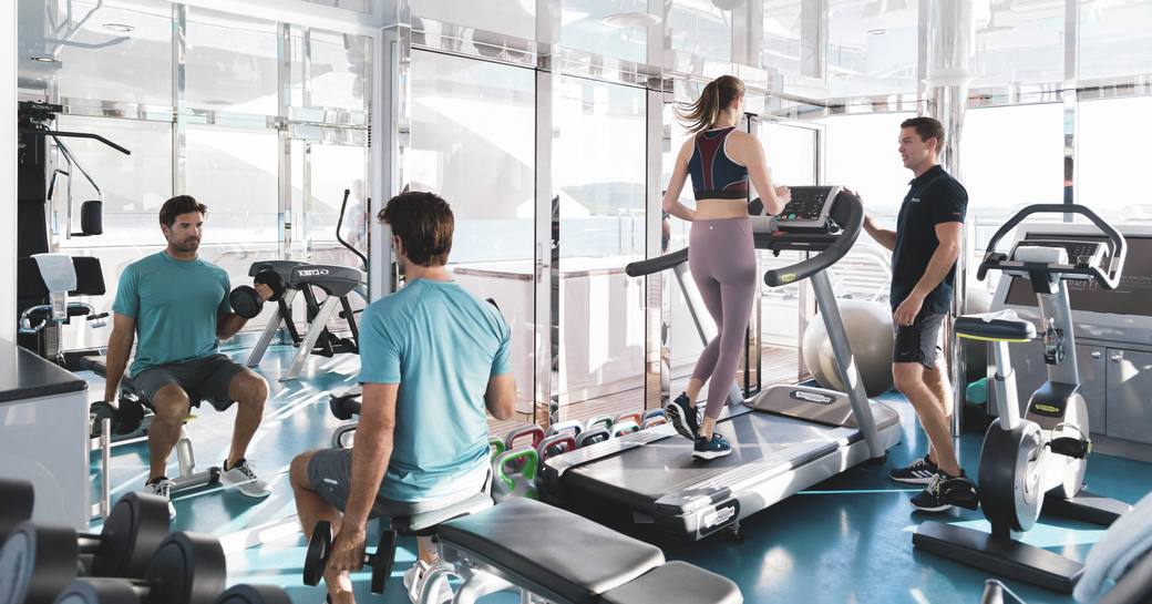Gym with charter guests using equipment onboard superyacht charter TITANIA