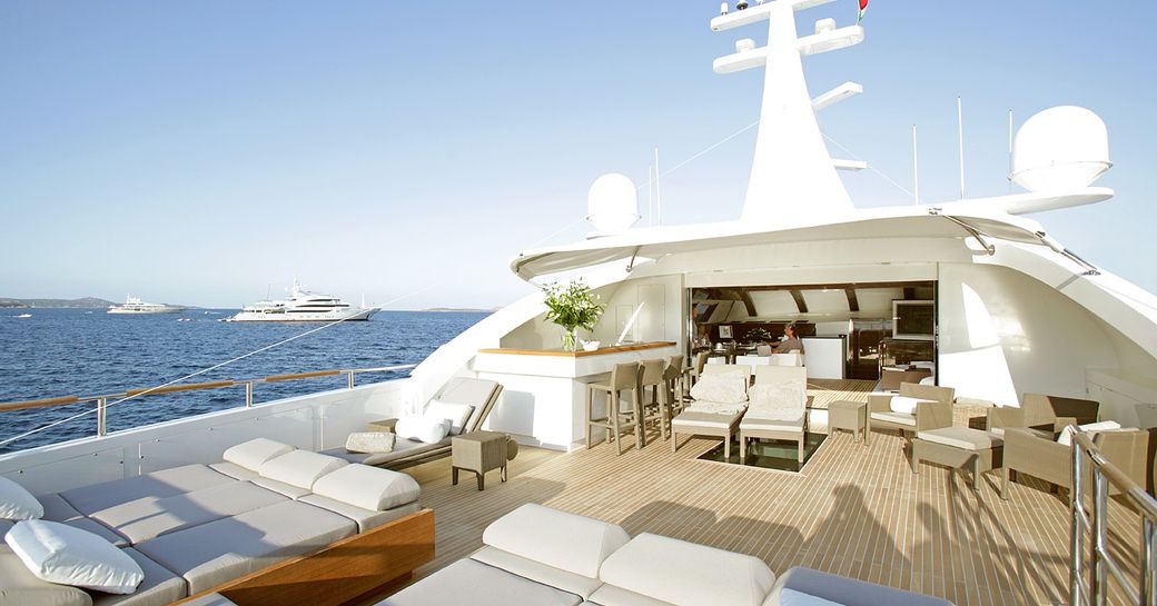 Foredeck of superyacht GEMS II, with teak flooring and lightly colored sun loungers
