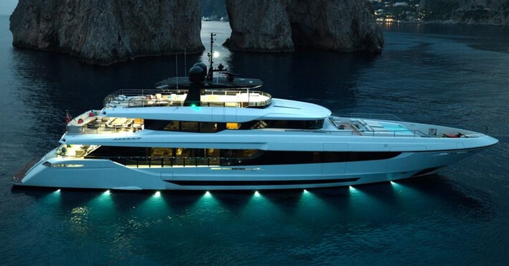 Motor yacht HALARA at sea with rock formations at dusk