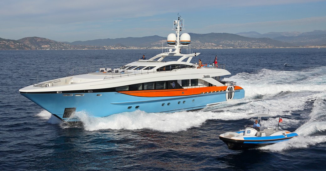 motor yacht AURELIA cuts through the water alongside her matching tender