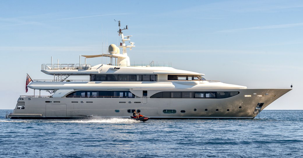 Charter yacht BEHIKE at anchor with a Jet Ski speeding along side