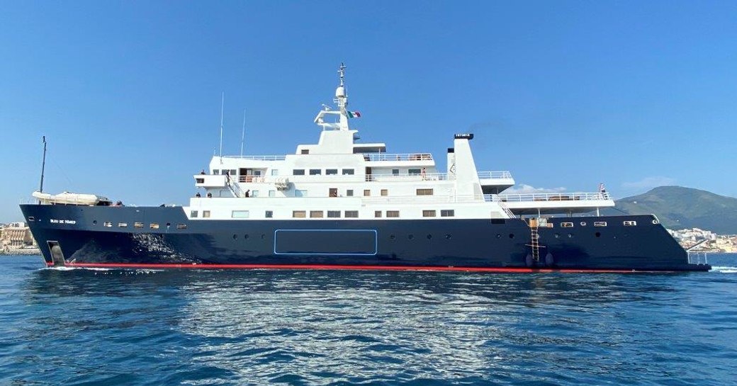 Charter yacht BLEU DE NIMES at sea with land in distant background