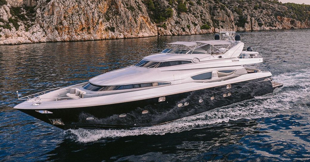 Charter yacht ELVI underway with cliff face to port