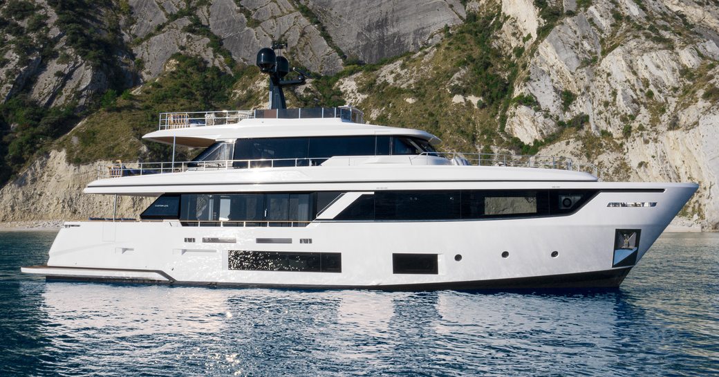 Charter yacht TWINS at anchor by cliffs