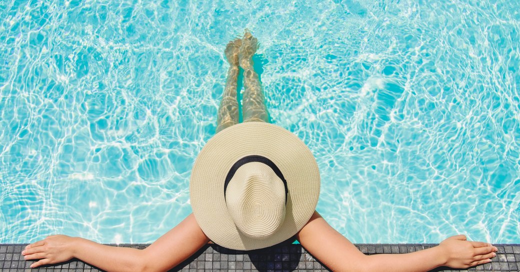 woman relaxing with hat on in a swimming pool