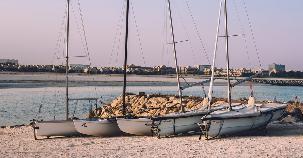 Al Hamra Village in Ras al Khaimah, United Arab Emirates. Sail boats on sand beach near Al Hamra marina and yacht club of RAK.