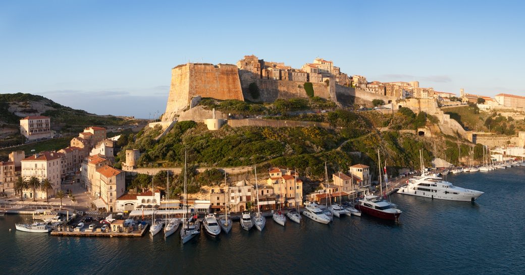 the town of Bonifacio teeters atop limestone cliffs with the harbour below in Corsica