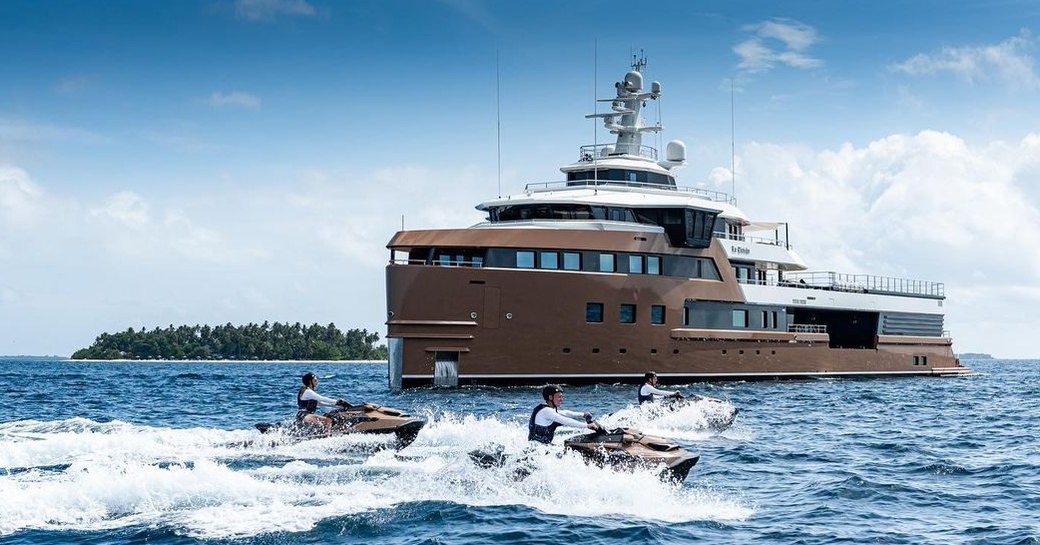 Charter yacht LA DATCHA at anchor with charter guests speeding around on water toys