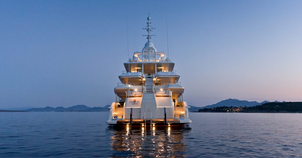 aft section of motor yacht Coral Ocean when anchored at sunset on a luxury yacht charter