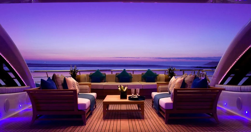 Comfortable seating and table on deck of superyacht Sea Rhapsody