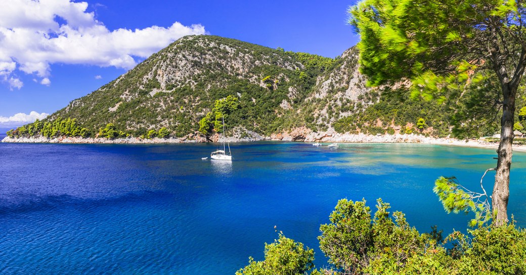 yacht in a bay of clear blue waters of skopelos