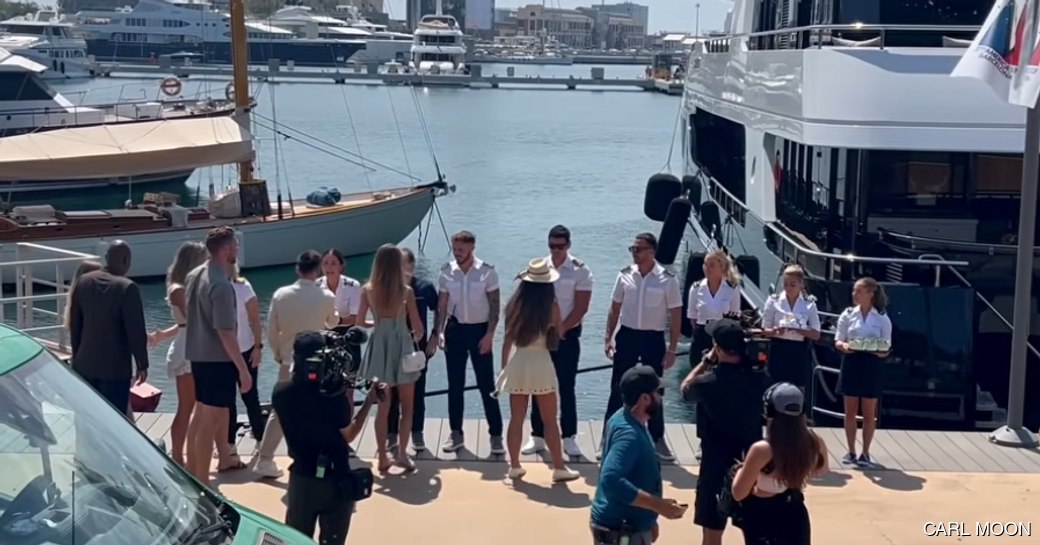 Below Deck crew on dock with charter guests and cameras