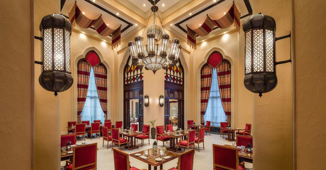 smart red chairs at angular tables in Mezlai Emirati Restaurant in Abu Dhabi