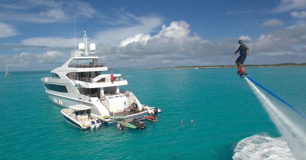 Charter guest flyboarding with charter yacht BIG SKY in the background