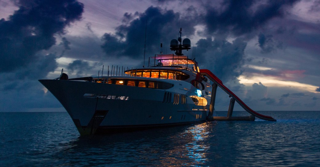 superyacht Amarula Sun anchored at night with water slide on a Caribbean charter vacation