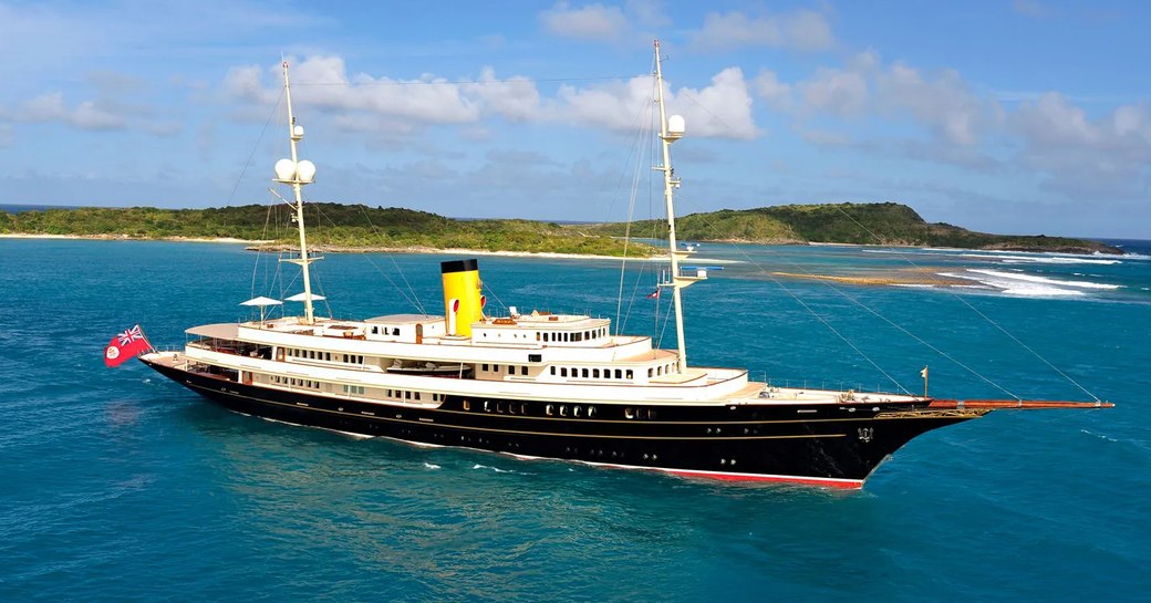 Charter yacht NERO underway, surrounded by sea and an island in the background