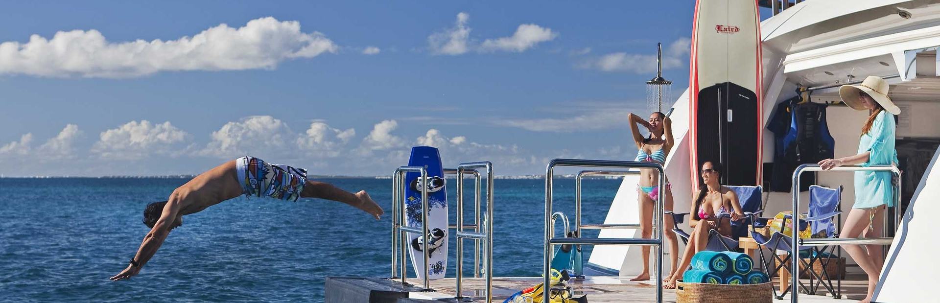 Charter guest diving off swim platform of Jaguar Superyacht