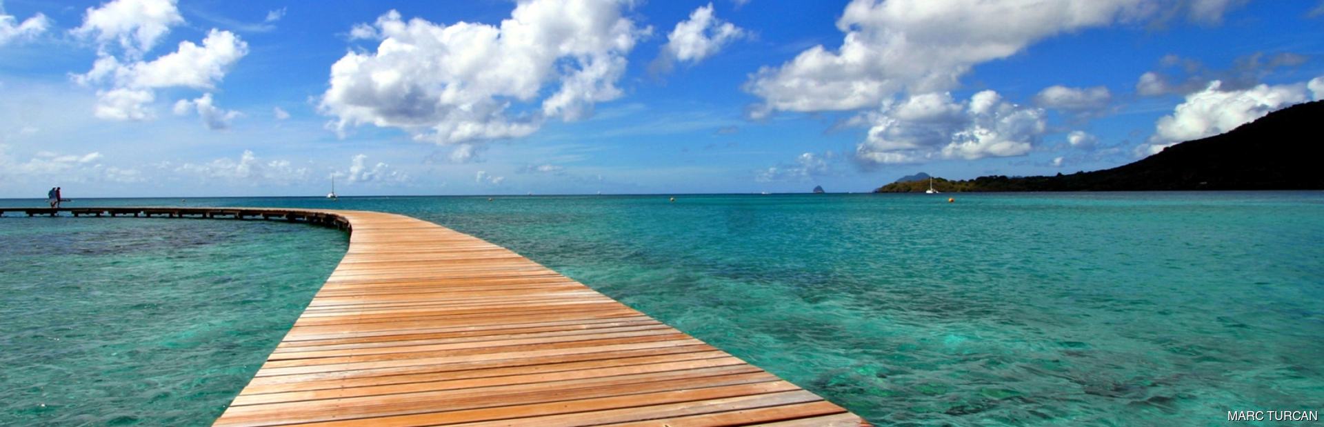 Wooden jetty and beautiful white cumulus clouds in the sky