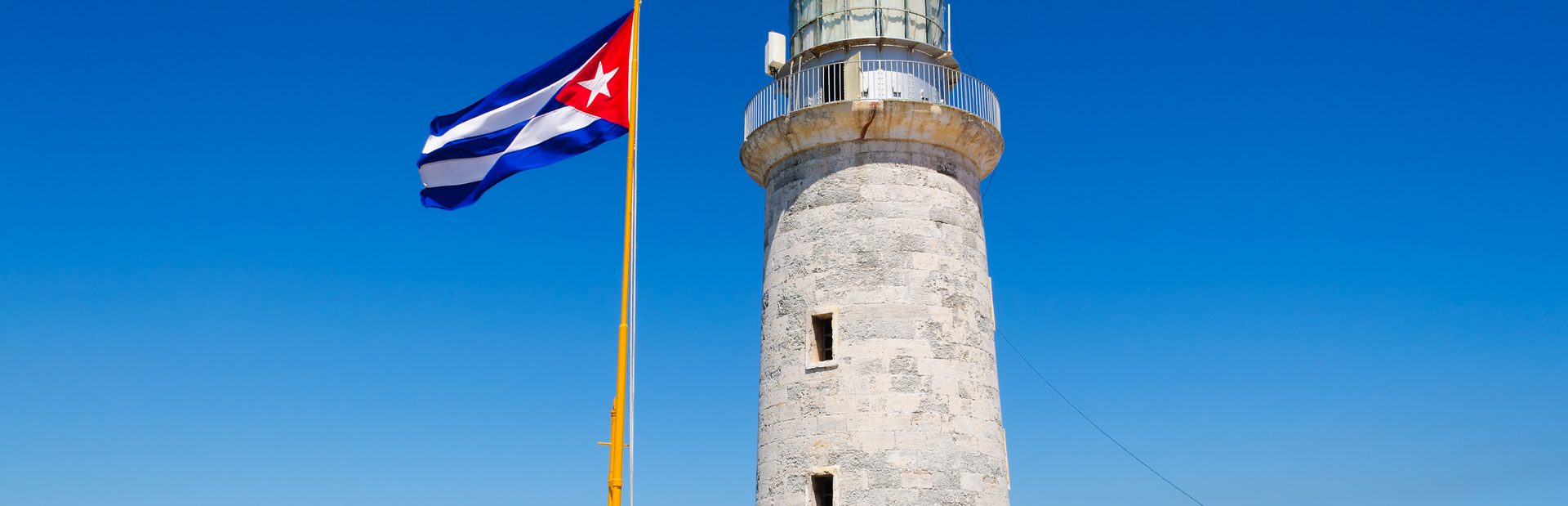 Waving Cuba flag next to the el Morro lighthouse